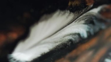 Boya dökülüyor. Mürekkep damlası. Odaklanmamış beyaz altın rengi sim sıvısı damla yayıyor hareket piramidi soyut sanat arka planı.