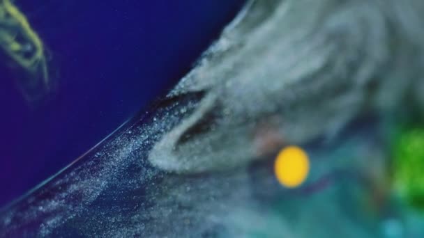 グリッターインクの背景 フッ素ミックス オイルペイントバブル 青い光る粒子 銀色の黄色い滑らかな質の顔料の抽象的なブレンドで浮かぶ脂肪円 — ストック動画