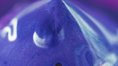 Parıltılı piramit. Boya dökülmüş. Odaklanmamış neon mavisi altın rengi parıldayan parçacıklar desen mürekkebi hareketli geometrik soyut sanat arkaplanı dökülüyor.