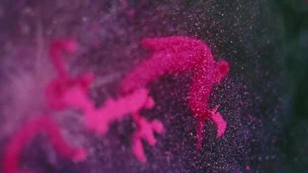 バックグラウンドドロップ グリッターインク水 トレンディな華やかなピンク色の輝く粒子の質の絵画 暗い液体物質で広がる抽象的な消しゴム — ストック動画
