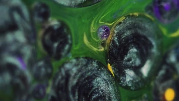 摘要背景 油漆混合气泡 闪光的液体艺术 绿色液体催眠设计中闪烁着的金属黑色银光油斑斑及黄色紫色水滴 — 图库视频影像