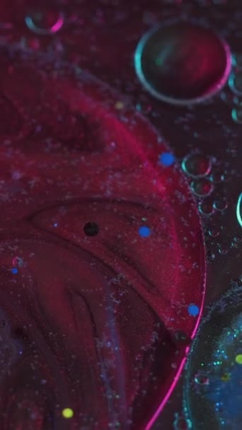垂直录像 色彩斑斓的液体背景 墨水泡沫混合在一起 抽象的行星宇宙艺术中的紫红 蓝色液体颜料在闪光物质表面上的运动 — 图库视频影像