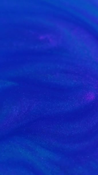 バーティカルビデオ 抽象的な背景 スパークリングインク 光沢のある粒子が流れている 輝く青いピンクの穀物の要素は装飾的な液体ペンキで広がる流れをします — ストック動画