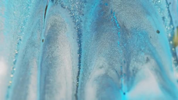 グリッターインクドリップ こぼれを塗る デフォーカスブルーホワイトゴールデンカラー 輝くテクスチャ流動モーション 装飾的な抽象的なアート背景 — ストック動画
