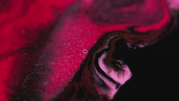 ペイントスプラッシュ インクミックス 分割された赤いピンクの黒い色の光沢のある粒子の質の液体のエマルションのブレンドの流れの暗い抽象的な芸術の背景 — ストック動画