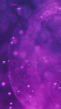 Dikey video. Soyut arkaplan. Yüzen kabarcıklar. Suyun altında. Deniz doğasında bulanık bokeh ışık noktalarıyla dolu mor renkli oksijen akışı sanatı..