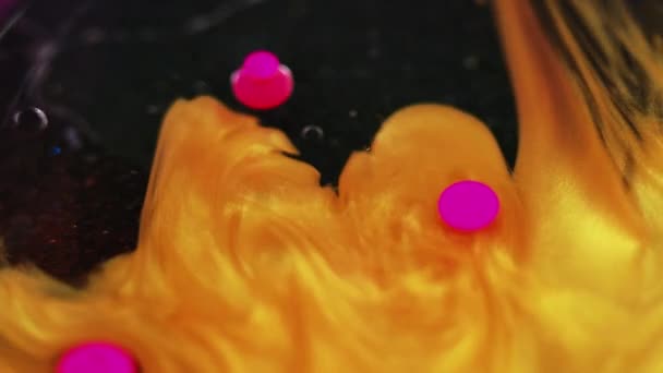 闪闪发光的液体飞溅 油漆水的混合物 浅黄粉色闪烁着光泽的亮晶晶的丙烯酸油墨气泡在黑色抽象艺术背景下的漂浮运动 — 图库视频影像