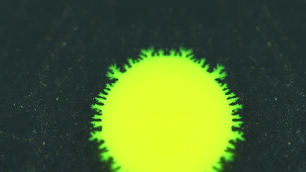 墨水掉了油漆飞溅 脱色霓虹灯黄绿色发光湿斑运动对深色闪光粒子的影响浅色纹理抽象背景揭示 — 图库视频影像