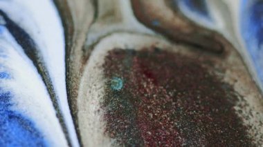 Boya dökülmüş. Parlak mürekkep damlası. Odaklanmamış mavi bronz beyaz renk parıldayan parlak parçacıklar bokeh hafif doku sıvı dalga kademeli hareket soyut sanat arka planı.