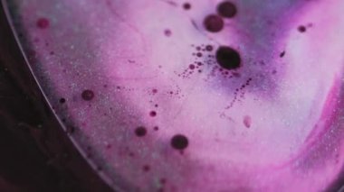 Parlak yağ balonu. Jel sıvısı damlası. Bulanık pembe mavi renk parıldayan desen koyu soyut sanat arka planına boya damlası.