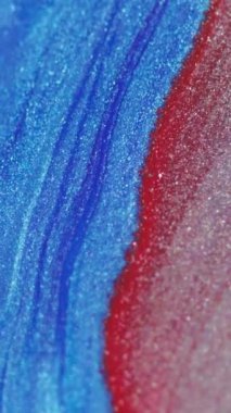 Dikey video. Mürekkep dalgası. Sıvı dökülmesi. Köpüklü sıvı yayılıyor. Parlak mavi pembe renkte metalik boya soyut arkaplan üzerine akışı.