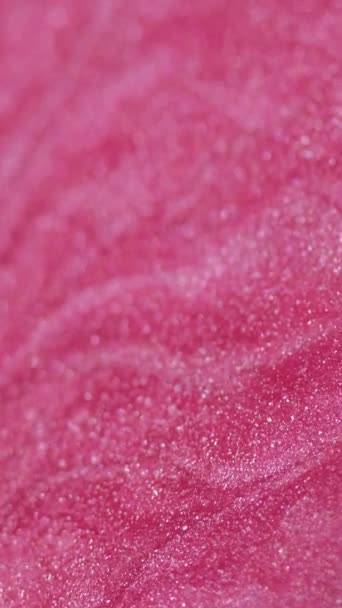 バーティカルビデオ グリッターフライド ペイントフロー スパークリングエナメル ピンク色のぬれた粒子の質インク波の芸術の抽象的な背景を薄暗くする分割された光沢 — ストック動画