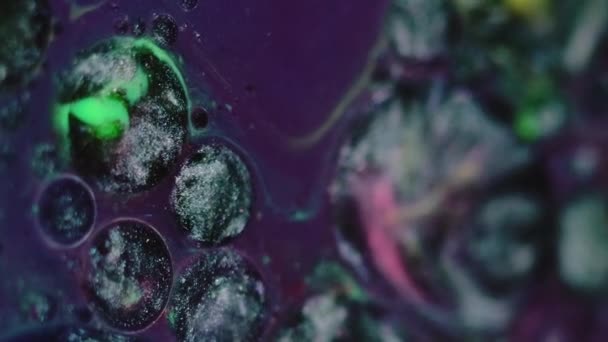 液体染料背景 闪闪发光的漩涡 彩色油的混合 紫色油墨表面有绿色红色黄斑的黑色白色抽象滴滴圈 — 图库视频影像