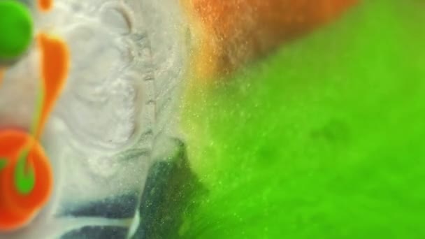 油漆混合背景 摘要油墨设计 幻想液体 具有鲜明橙色绿色白色滴在透明的黑色底部闪光物质上的圆圆的浮油 — 图库视频影像