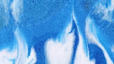 Parlak mürekkep damlası. Parıldayan sıvı. Odaklanmamış mavi beyaz renkli parlak desenli boya parlatıcısı kış hareketi soyut sanat arka planı.