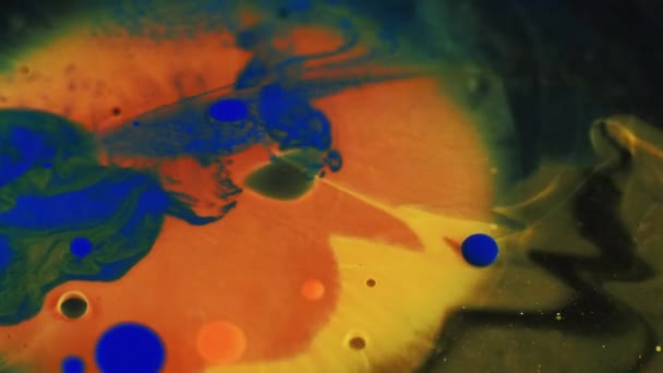 ペイントスプラッシュ オイルバブル インクウォーターミックス ブラックパーティクルテクスチャ抽象アートバック上の不分割されたオレンジ色の染料エマルションブロブフローの動き — ストック動画