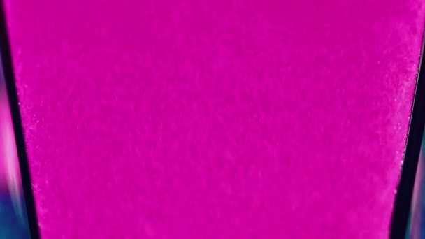 ピンクのこぼれ グリッターペンキ ビビッド ウォーターフォール 分解された明るい色の光る粒子の質のガラス表面の抽象的な背景の魅力的なぬれたインクの流れの動き — ストック動画