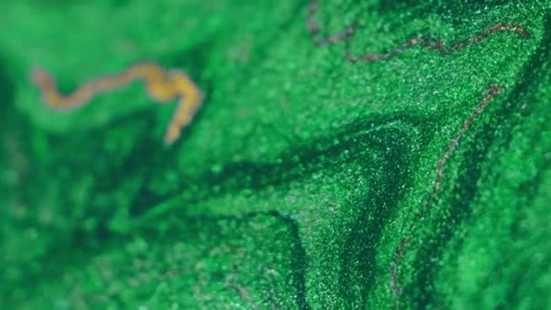 バーティカルビデオ 液体塗装の背景 シャイミングドリップ 抽象芸術の銀の輝く表面に広がる金の光沢のある液体インクの混合物の低下が付いている流行の緑色 — ストック動画