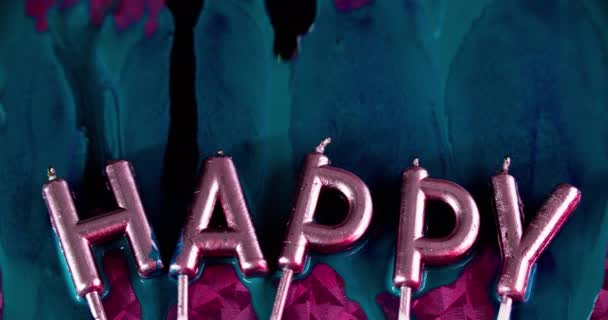ハッピーバースデー ホリデー挨拶 インク流出 ピンクの表面の抽象的な芸術の背景の青い黒い色のペンキの液体のドリップの流れが付いている虹彩の光の金属の手紙のろうそく — ストック動画