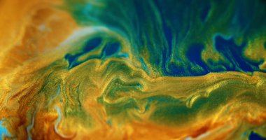 Işıl ışıl. Mürekkep dalgası. Islak, ışıl ışıl bir doku. Odaklanmamış mavi altın rengi parlak metalik kum parçacıkları sıvı pigment karışımı soyut sanat arkaplanı boyar.