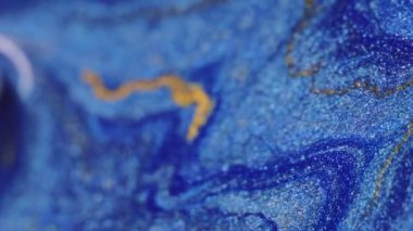 Dikey video. Boya karışımı arka plan. Parlak mürekkep damlası. Işıl ışıl dökülüyor. Pürüzsüz doku parlak mavi renk ve gümüş mermer efekt yüzeyinde altın akışı soyut sanatta.