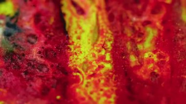 Parlak sıvı akışı. Boya karıştırıcı su. Odaklanmamış kırmızı sarı siyah renk parıldayan parçacıklar desen mürekkep kabarcıkları hareket eden soyut sanat arkaplanı.
