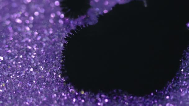 インクドロップ ペイントスプラッター 光沢のあるヴァイオレットの紫色の輝く粒子ボケの光の質の抽象的な背景の分離された黒いぬれた汚れの汚れの汚れの動きは効果を明らかにします — ストック動画