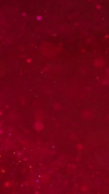 Dikey video. Bokeh ışıkları. Işıldayan sıvı. Odaklanmamış ışıl ışıl parıldayan noktalar parlak yüzen hareketler canlı kırmızı mavi sıvı soyut arka planda.