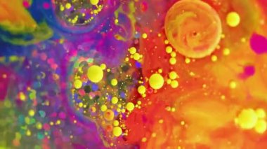 Dikey video. Sıvı boya arka planı. Renk sıvısı karışımı. Yağ hareketi sanatı. Turuncu mavi mor madde soyut baloncuklar suda dönen hipnotize edici yanardöner parlak parçacıklar.