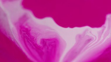 Mürekkep damlası. Sıvı dökülmesi. Odaklanmamış pembe beyaz pigment sıvı boya damlaları hareket yaratıcı sanat soyut arka plan yayıyor.