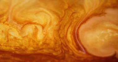 Parlak sıvı damlası. Parlak boya akışı. Odaklanmamış altın sarısı beyaz renk parıldayan pullu kum parçacıkları mürekkep rengi pigment dalga hareketi soyut sanat arkaplanı.