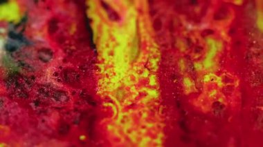 Parlak sıvı akışı. Boya karıştırıcı su. Odaklanmamış kırmızı sarı siyah renk parıldayan parçacıklar desen mürekkep kabarcıkları hareket eden soyut sanat arkaplanı.
