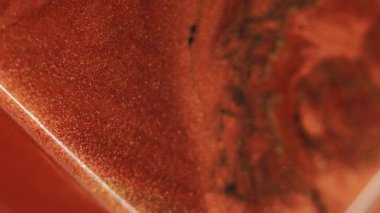 Parıltılı boya döküldü. Mürekkep akıyor. Odaklanmamış bronz kırmızı siyah renk ışıl ışıl sıvı emülsiyon akışı küp geometrik soyut sanat arka planı.