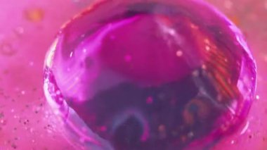 Neon prizması. Islak, ışıl ışıl bir doku. Odaklanmamış mor menekşe renk holografi kristali parlak sıvı parıltı partikülleri yanardöner ışık soyut sanat arkaplanı damlatıyor.