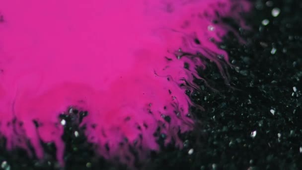 墨水洒了油漆斑斑 模糊的霓虹灯粉色液体在深黑色光泽粒子纹理上的扩散抽象艺术背景开瓶器效果 — 图库视频影像