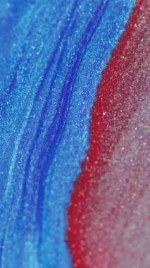 Dikey video. Mürekkep dalgası. Sıvı dökülmesi. Köpüklü sıvı yayılıyor. Parlak mavi pembe renkte metalik boya soyut arkaplan üzerine akışı.