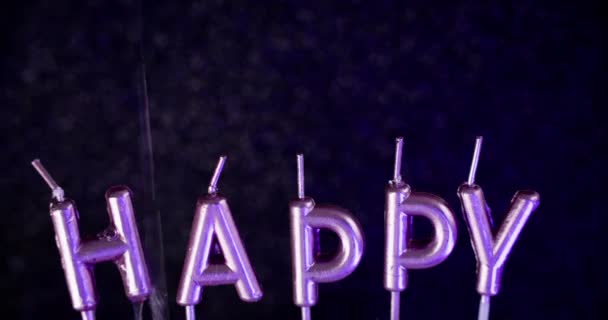 ハッピーバースデー ホリデーフォント お祝いの黒いボケの光の抽象的なアート背景に虹彩色の水液で振りかける銀製の光沢のある文字キャンドル — ストック動画