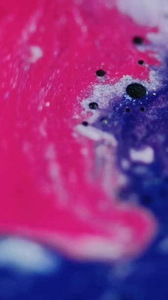 バーティカルビデオ 液体塗装の背景 シャイミングドリップ ファンタジーミックスアート トレンディなピンク色の輝く液体インク抽象的なドロップは青い白いスパークリング染料で広がります — ストック動画