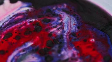 Mürekkep döküldü. Boya lekeleri. Odaklanmamış siyah mavi pembe renkli simli sıvı kirli damlalarla akıyor yağ karışımı hareketli soyut sanat arkaplanı.