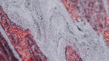 Parıltılı boya döküldü. Mürekkep dalgası. Odaklanmamış kırmızı gri renkli parıldayan parlak parçacıklar mermer desen sıvı akış soyut sanat arka planı.