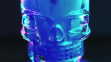 Neon iskelet. Parlak boya kafatası. Siber ölüm. Odaklanmamış floresan pembe mavi renk. Parlayan mürekkep sıvısı. Siyah soyut sanat arka planında cam kranyum..