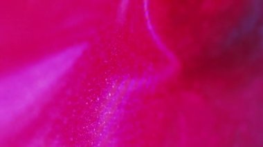 Islak sim dökülmüş. Metalik sıvı. Bulanık neon parlak morumsu pembe parıldayan sıvı boya damlaları soyut sanat arka planı.