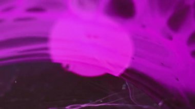 Mürekkep damlası su. Neon sisi. Boya sıçraması. Bulanık pembe renk buhar dokusu koyu siyah soyut sanat arka planında sıvı damla dalgası.