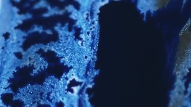 Mürekkep döküldü. Parıltılı boya akışı. Odaklanmamış mavi renk parıldayan parçacıklar dokusu sıvı parlatıcı dalga hareketinin soyut sanat arkaplanı.