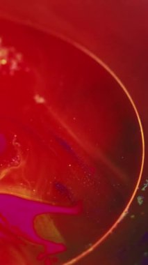 Parıltılı boya suyu. Mürekkep girdabı. Bulanık kırmızı, mor, sarı, parlak, ışıl ışıl, sıvı, kabarcık, dalgalı, soyut arka plan sanatı..