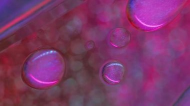 Parlayan yağ damlacıkları. Neon köpükleri. Bulanık pembe renk parıldayan boya damlaları Bokeh hafif cam desen soyut sanat arkaplan.