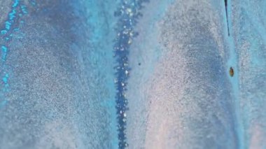 Islak sim dökülmüş. Mürekkep damlası. Bulanık mavi beyaz altın rengi parlak metalik parçacıklar dokusu boya sıvısı akışı soyut sanat arka planı.