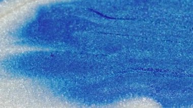 Parlak boya dalgası. Islak sim akışı. Bulanık sanat arkaplanı üzerinde mavi beyaz parıldayan parçacıklar akrilik mürekkep hareketi.