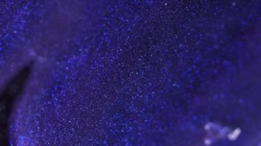 Işıldayan doku. Islak sim akışı. Odaklanmamış mavi mor renk parıltılı boya dalgası, parlak cazibe, karanlık, soyut sanat arkaplanı..