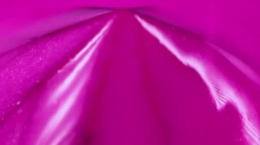 Soyut arkaplan. Köpüklü sıvı. Islak sim akışı. Bulanık renkli pembe sıvı mürekkep akışı. Parıldayan parçacıklar piramit yüzeyine damlıyor..